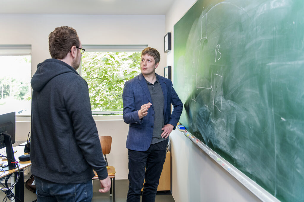 Medarbejder fra SkoleIT taler med en person foran en tavle i et klasselokale